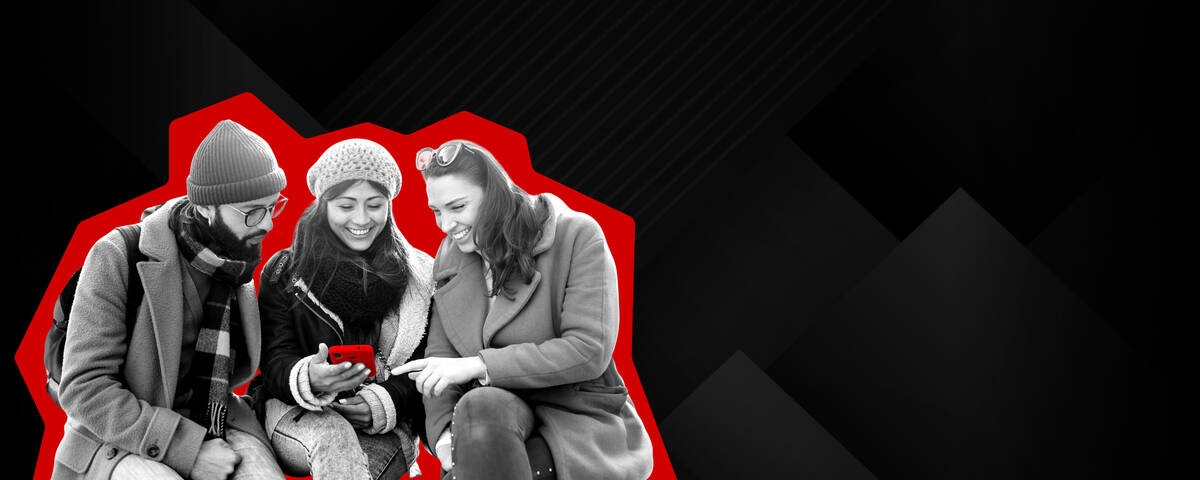 Gute Freundschaft zahlt sich aus! Zwei Frauen stehen lächelnd nebeneinander und schauen auf ihr Handy